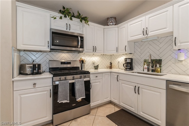 kitchen with white cabinetry, backsplash, and appliances with stainless steel finishes