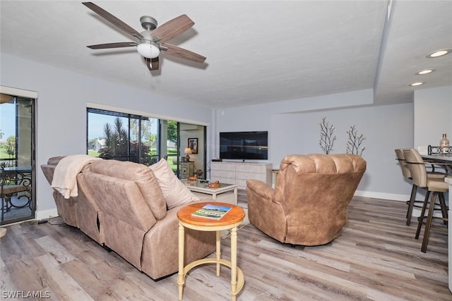 living room with light wood-type flooring and ceiling fan