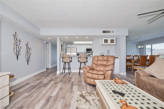 living room with ceiling fan and light hardwood / wood-style floors