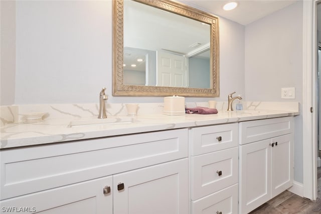 bathroom with dual vanity and hardwood / wood-style floors