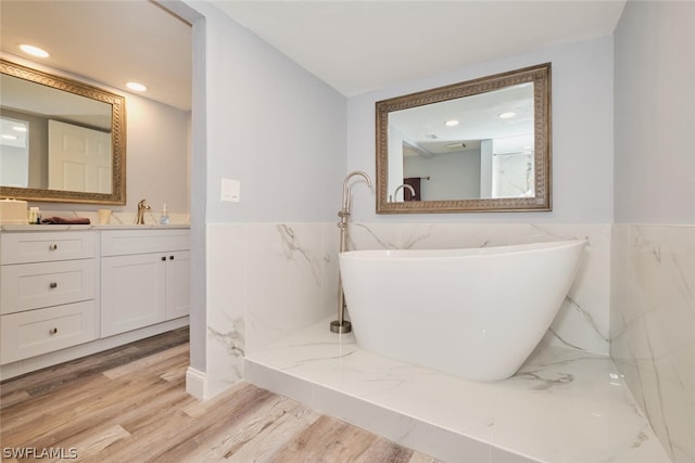 bathroom with tile walls, hardwood / wood-style floors, and vanity