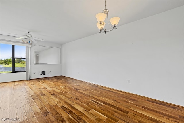 unfurnished living room with ceiling fan with notable chandelier and wood-type flooring