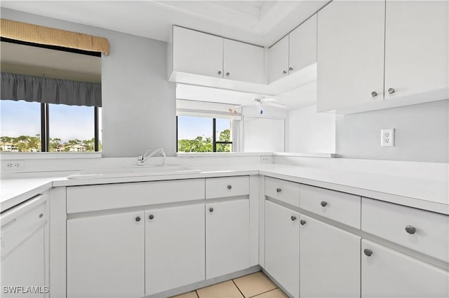 kitchen with sink, white cabinets, and light tile patterned flooring