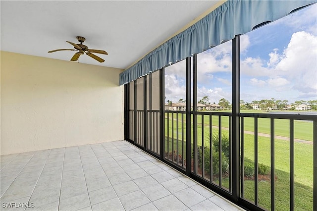 unfurnished sunroom with ceiling fan