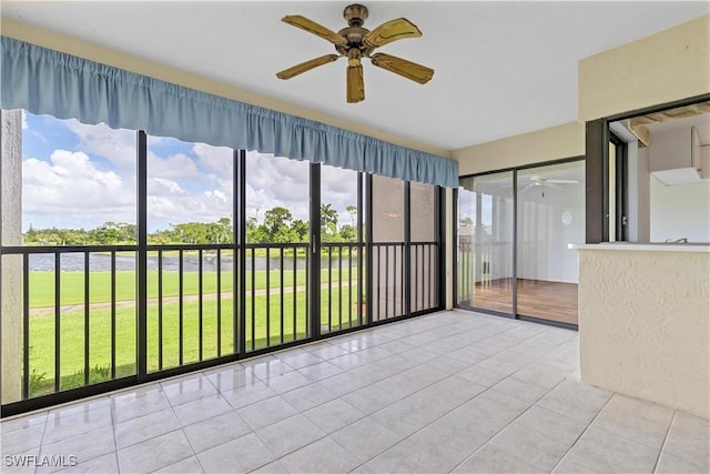 unfurnished sunroom featuring ceiling fan