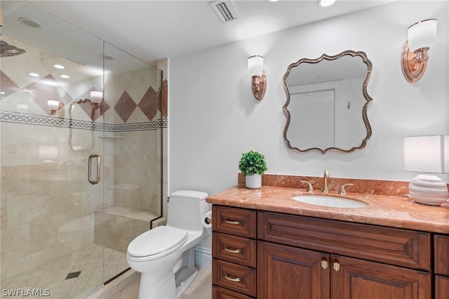 bathroom with a shower with door, vanity, and toilet