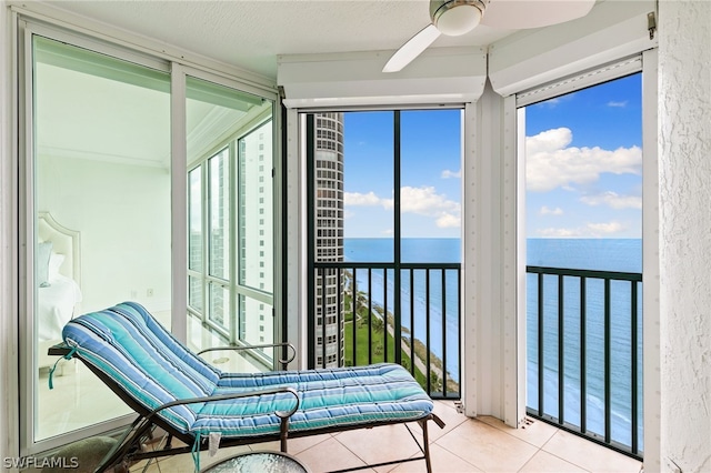 sunroom with a water view and ceiling fan