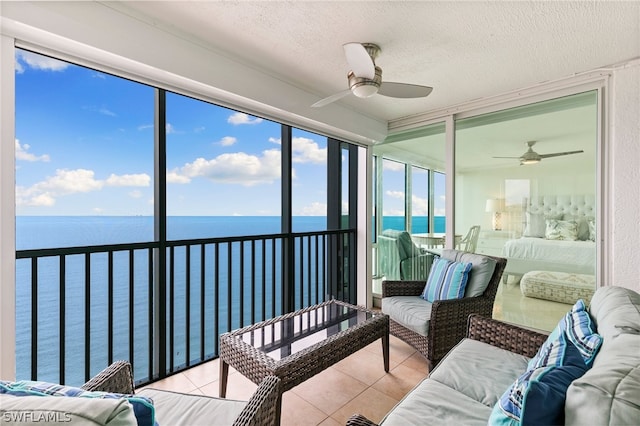 sunroom with a water view and ceiling fan