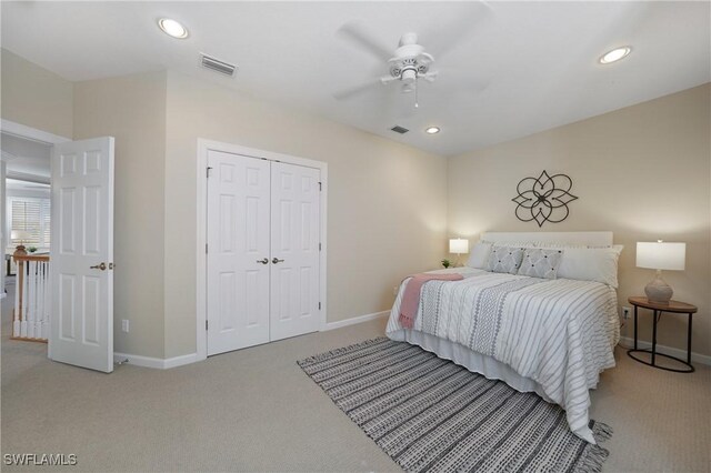 bedroom featuring light colored carpet, a closet, and ceiling fan