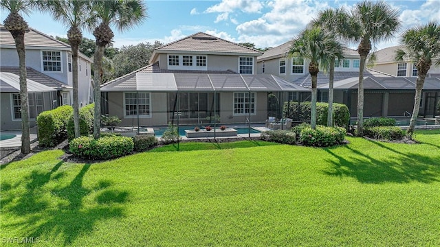 rear view of house with a lanai and a lawn