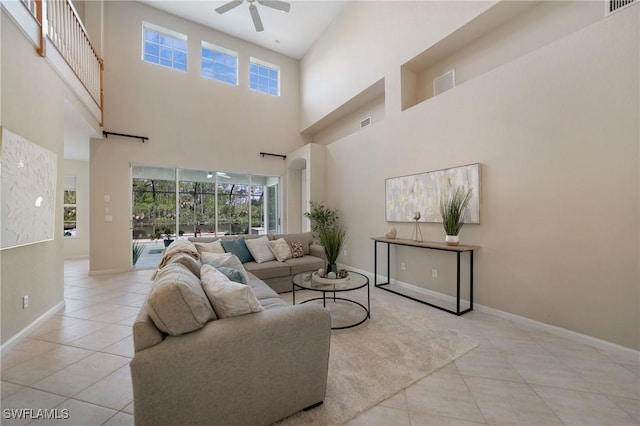 living room with light tile patterned flooring, a towering ceiling, and ceiling fan