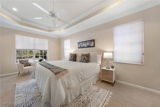 carpeted bedroom with crown molding, ceiling fan, and a tray ceiling