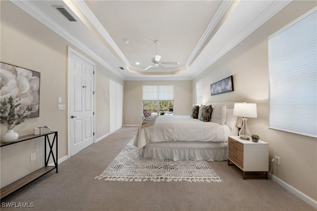 carpeted bedroom featuring a raised ceiling, crown molding, and ceiling fan