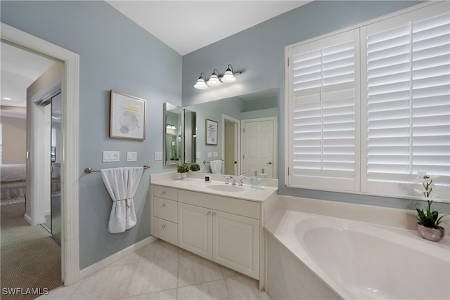 bathroom with tile patterned flooring, a washtub, and vanity