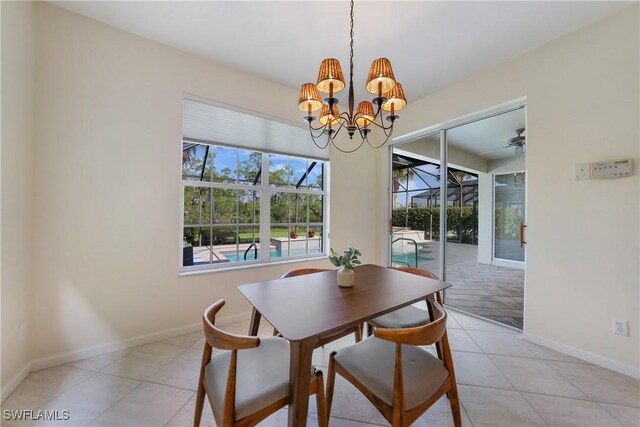 tiled dining space featuring ceiling fan with notable chandelier