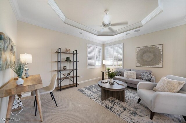 carpeted living room featuring crown molding, ceiling fan, and a raised ceiling