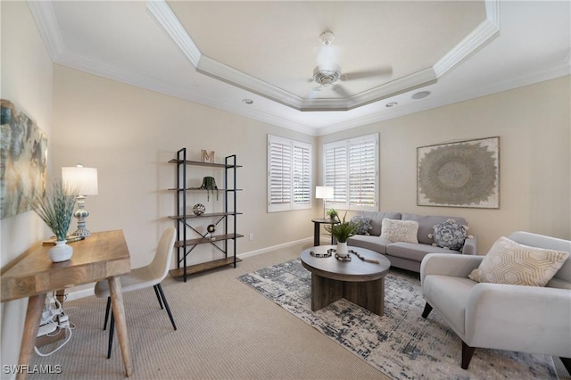 living room featuring a raised ceiling, crown molding, carpet, and ceiling fan