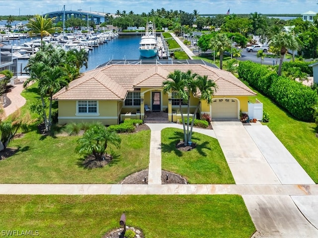 view of front of house featuring a dock, a water view, a garage, and a front lawn