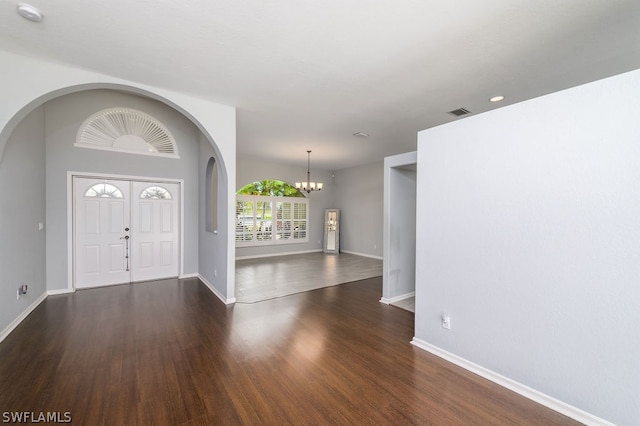 foyer entrance with wood-type flooring and a chandelier