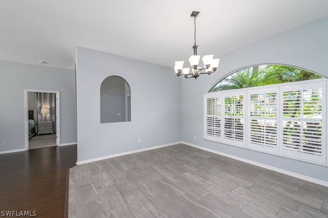 empty room with an inviting chandelier and hardwood / wood-style flooring