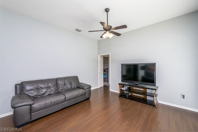 living room featuring ceiling fan and dark wood-type flooring