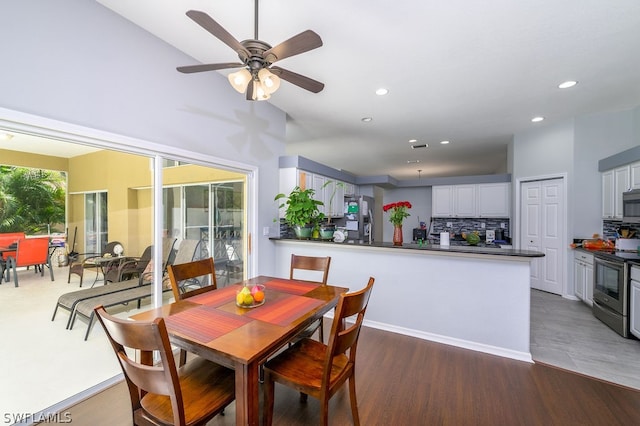 dining area with ceiling fan, lofted ceiling, and hardwood / wood-style floors