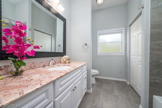 bathroom featuring tile patterned flooring, toilet, and vanity