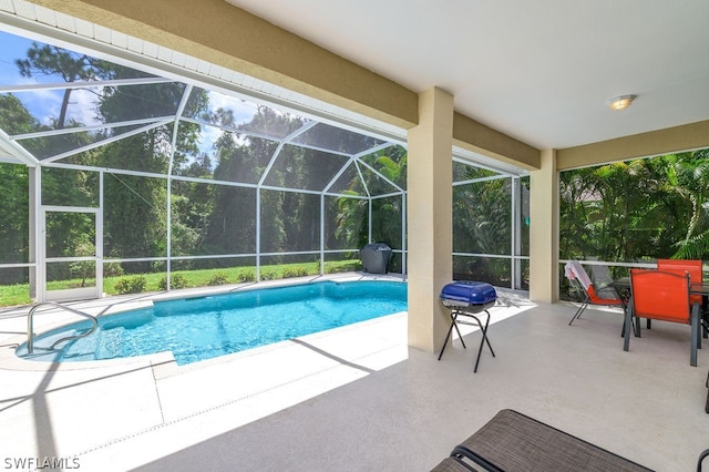 view of pool featuring glass enclosure and a patio area