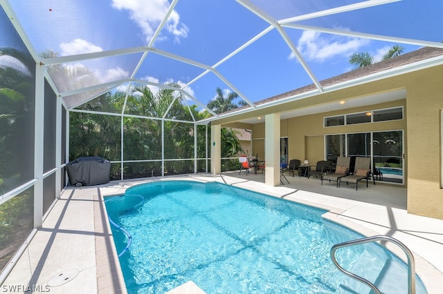 view of swimming pool with a patio area and a lanai