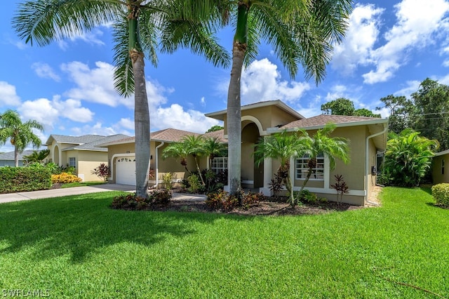 mediterranean / spanish-style house with a garage and a front yard