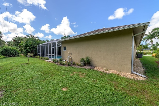 exterior space featuring central AC, a yard, and glass enclosure