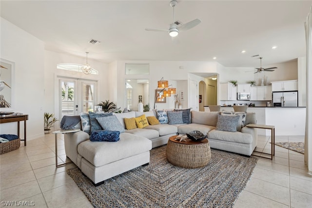 tiled living room featuring ceiling fan with notable chandelier