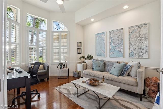 living room featuring ceiling fan and dark hardwood / wood-style floors