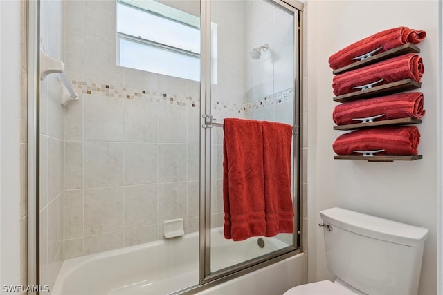 bathroom featuring enclosed tub / shower combo and toilet