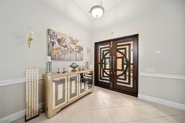 entrance foyer with french doors, lofted ceiling, and light tile patterned floors