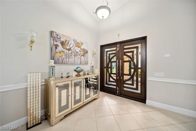 tiled entryway with vaulted ceiling and french doors