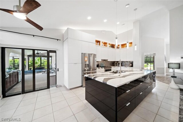 kitchen featuring white cabinetry, light tile patterned floors, ceiling fan, stainless steel appliances, and decorative backsplash