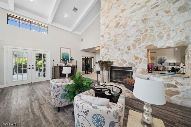 living room with a stone fireplace, french doors, beam ceiling, high vaulted ceiling, and wood-type flooring