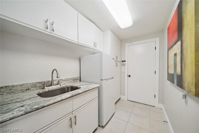 laundry area featuring sink and light tile patterned floors