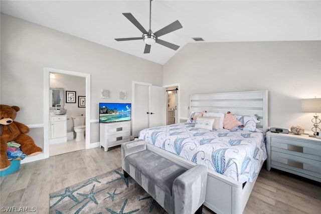 bedroom with ensuite bath, ceiling fan, light hardwood / wood-style floors, and high vaulted ceiling