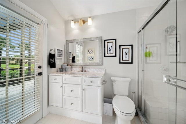 bathroom featuring a shower with shower door, vanity, tile patterned flooring, and toilet