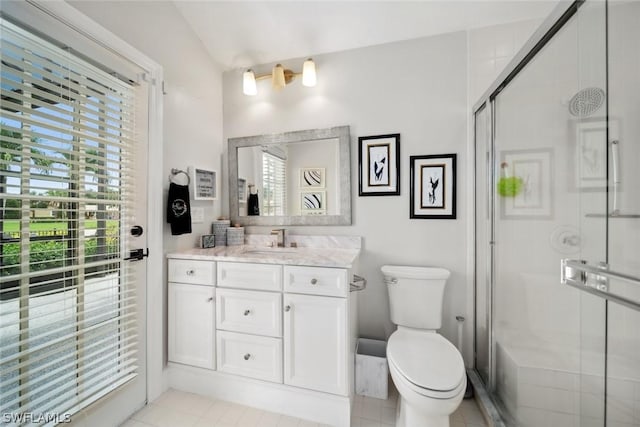 bathroom featuring vanity, a shower with shower door, and toilet