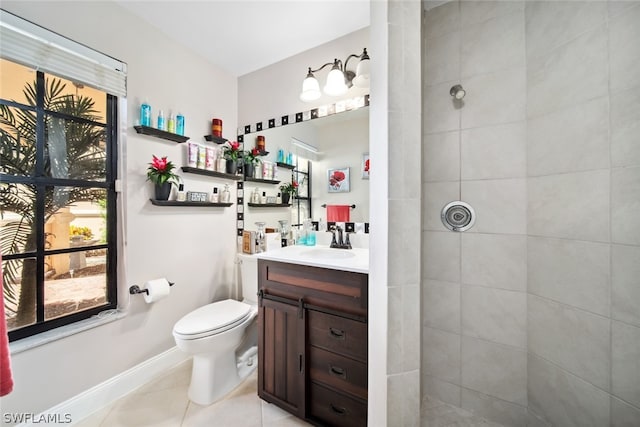 bathroom with tiled shower, vanity, tile patterned flooring, and toilet