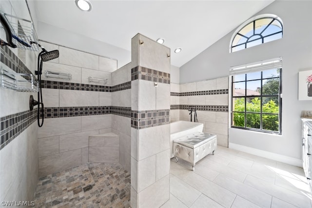 bathroom with tile patterned flooring, tile walls, shower with separate bathtub, lofted ceiling, and vanity