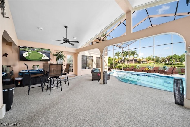 view of swimming pool featuring ceiling fan, an outdoor living space, a patio area, and glass enclosure