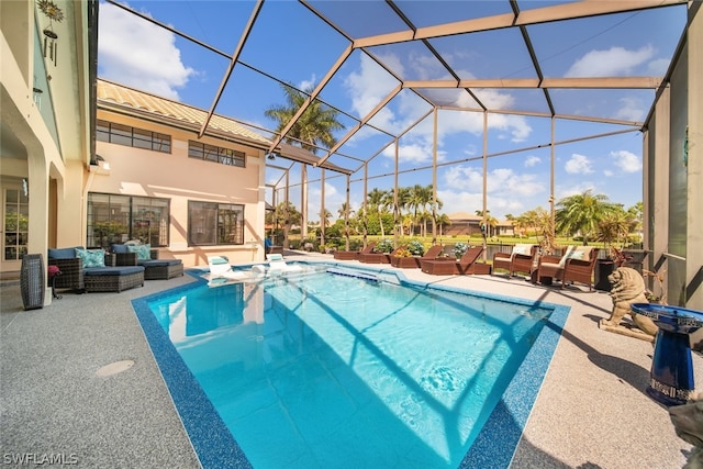 view of pool featuring glass enclosure, a patio area, and an outdoor living space