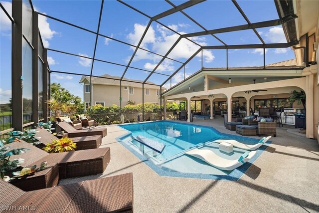 view of swimming pool with a lanai, a patio area, outdoor lounge area, and ceiling fan