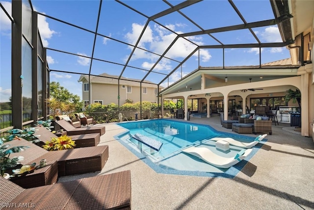 view of swimming pool featuring a patio, outdoor lounge area, ceiling fan, and glass enclosure