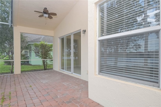 unfurnished sunroom featuring ceiling fan