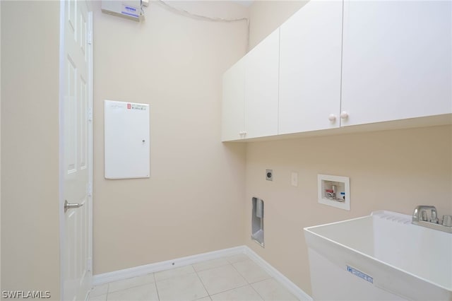 washroom featuring light tile patterned flooring, sink, electric dryer hookup, cabinets, and washer hookup